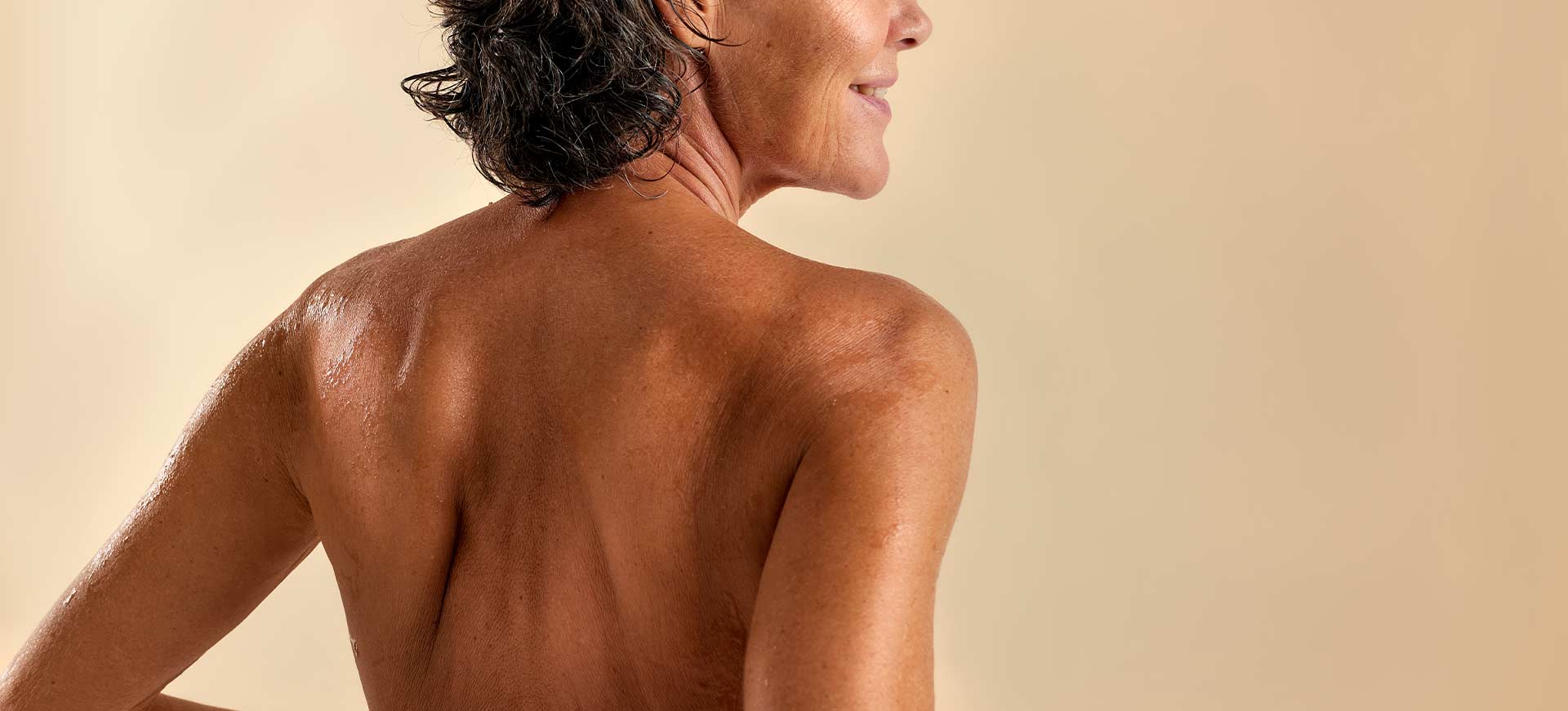 Mujer sonriendo y mostrando su espalda